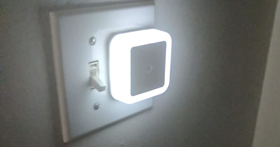 small white square nightlight plugged into outlet