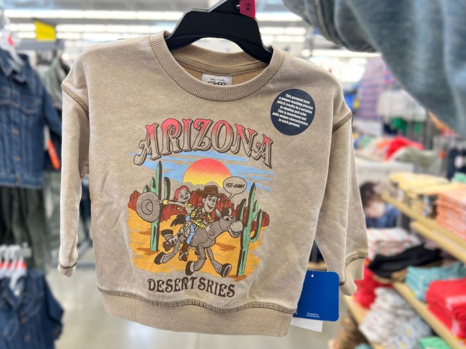 hand holding a toddler's Toy Story dessert scene tan color vintage wash sweatshirt