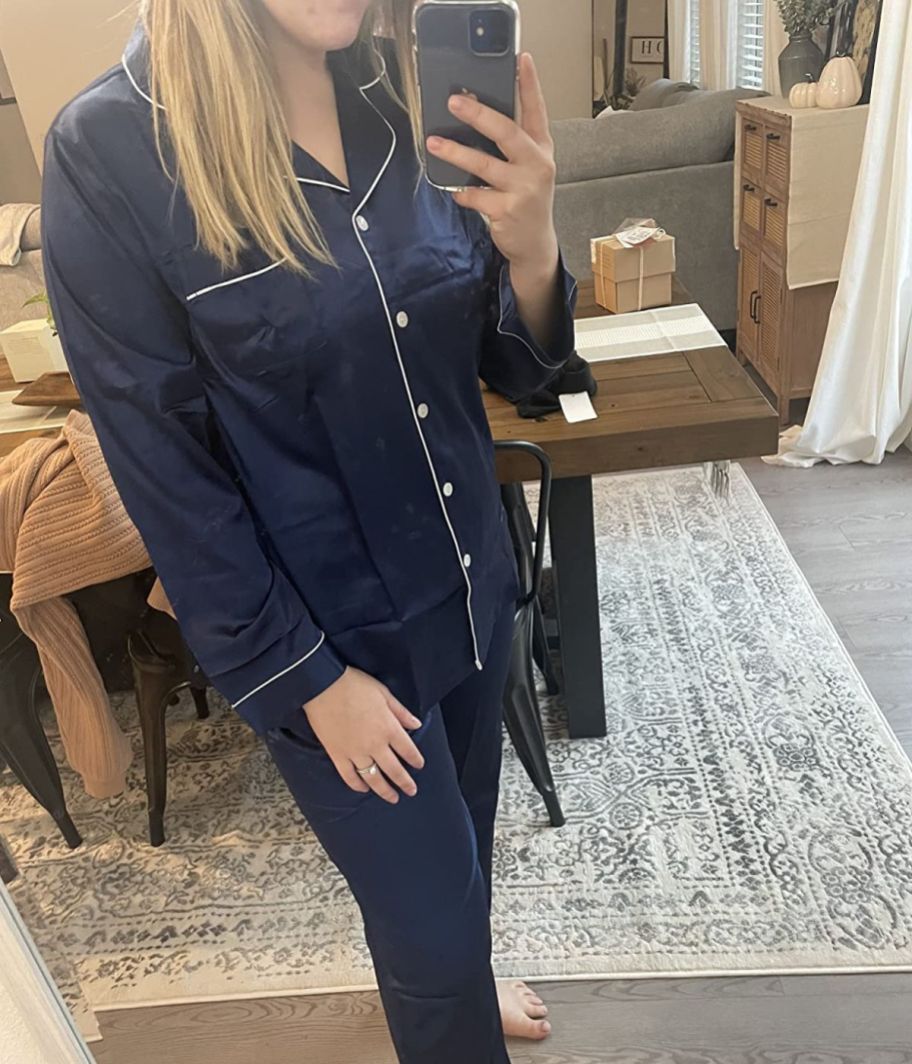 woman taking a selfie wearing a navy blue set of satin pajama pants