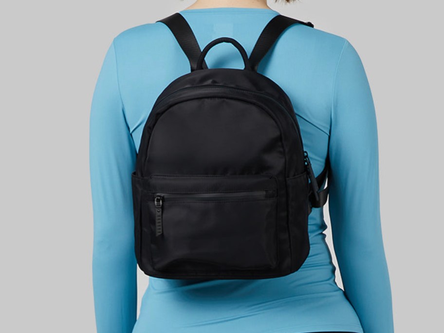 woman in blue shirt wearing black backpack