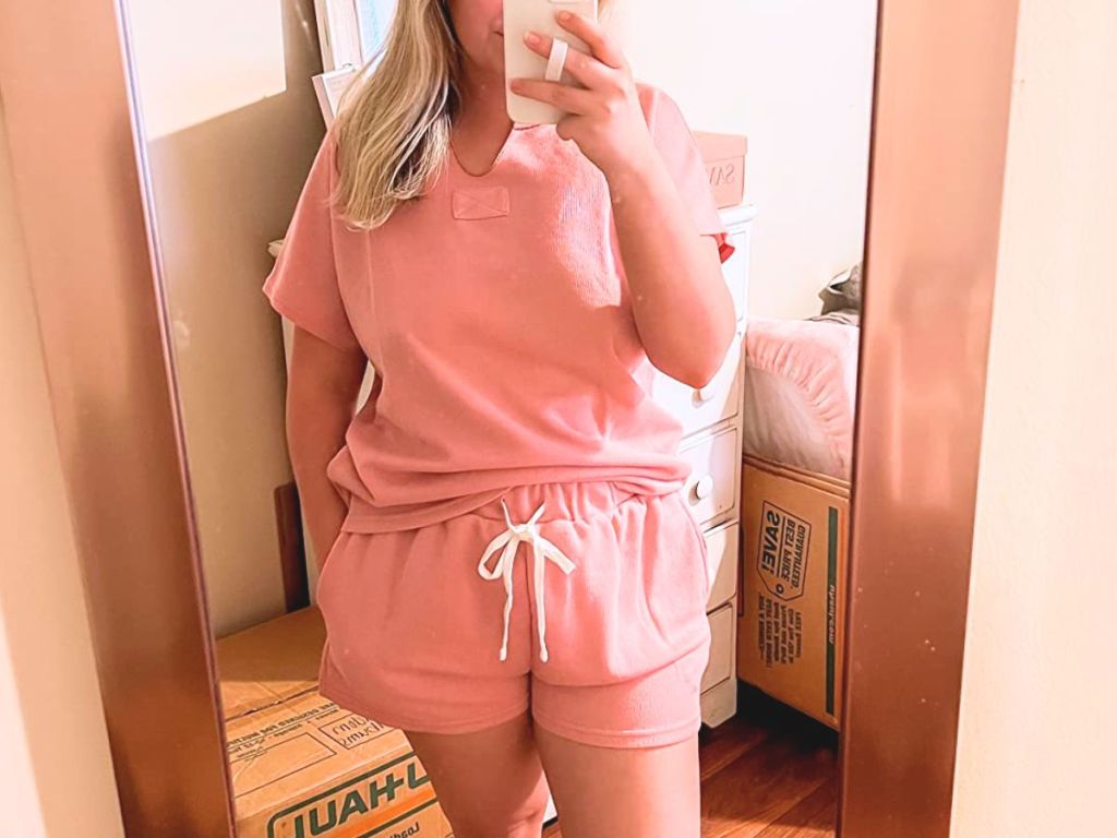 woman taking a selfie in the mirror wearing a pink 2 pc lounge or pajama set