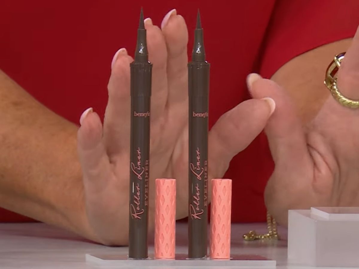 Benefit Cosmetics Eyeliners on a display with woman's hands behind them