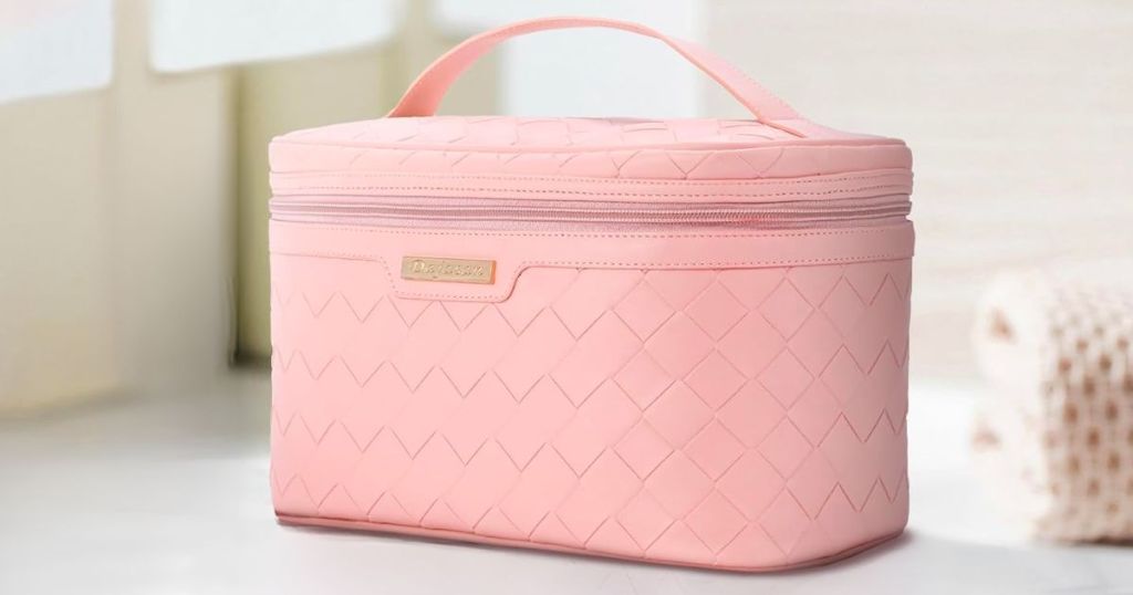 a Large Capacity pink Travel Cosmetic Bag sitting on a white marble counter