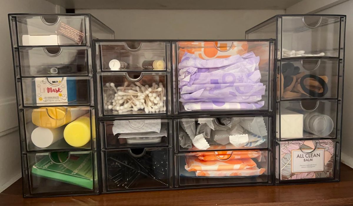 4 piece set of clear acrylic organizer drawers filled with personal care items.
