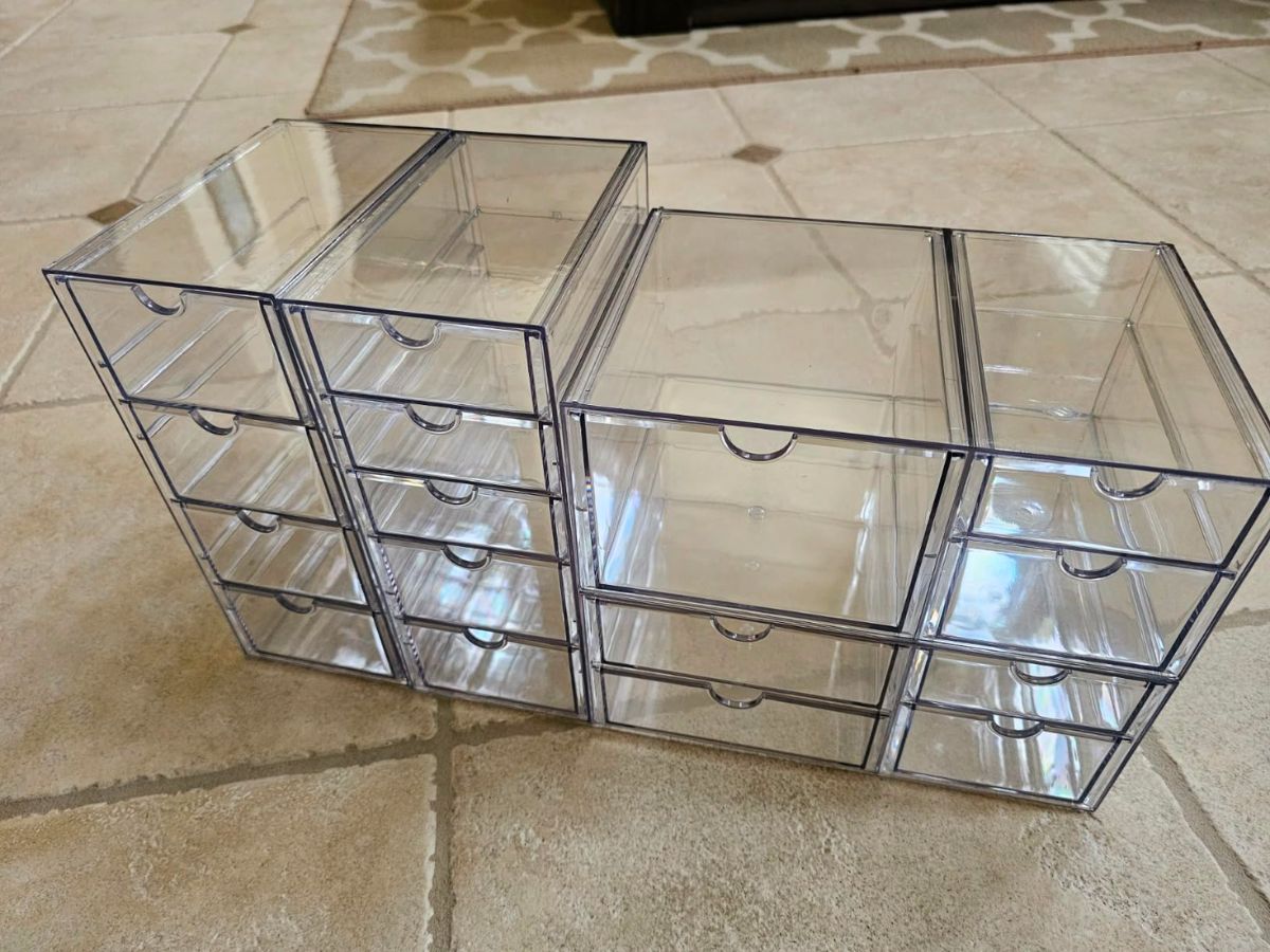 4 piece set of clear acrylic organizer drawers sitting on a tile floor
