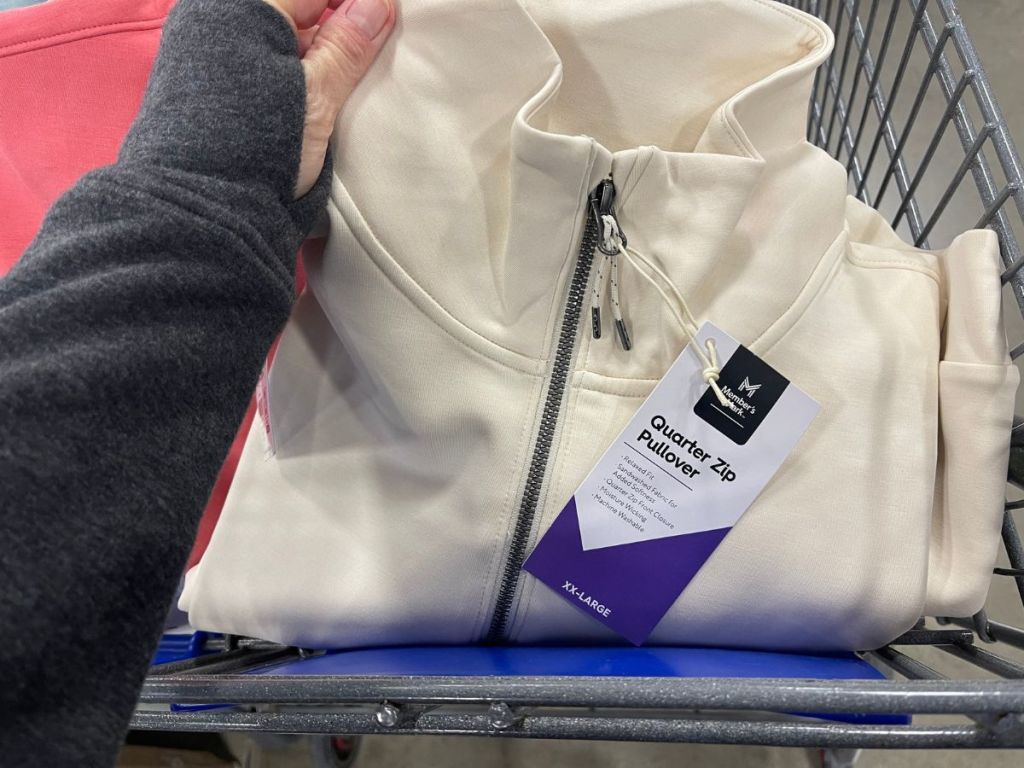 cream color women's quarter zip pullover in person's hand and cart at Sam's Club