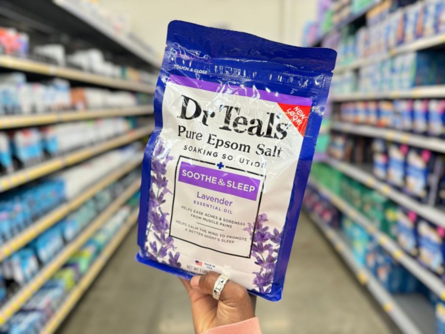 hand holding a large bag of Dr Teal's Epsom Salt Soaking Solution, Soothe & Sleep, Lavender