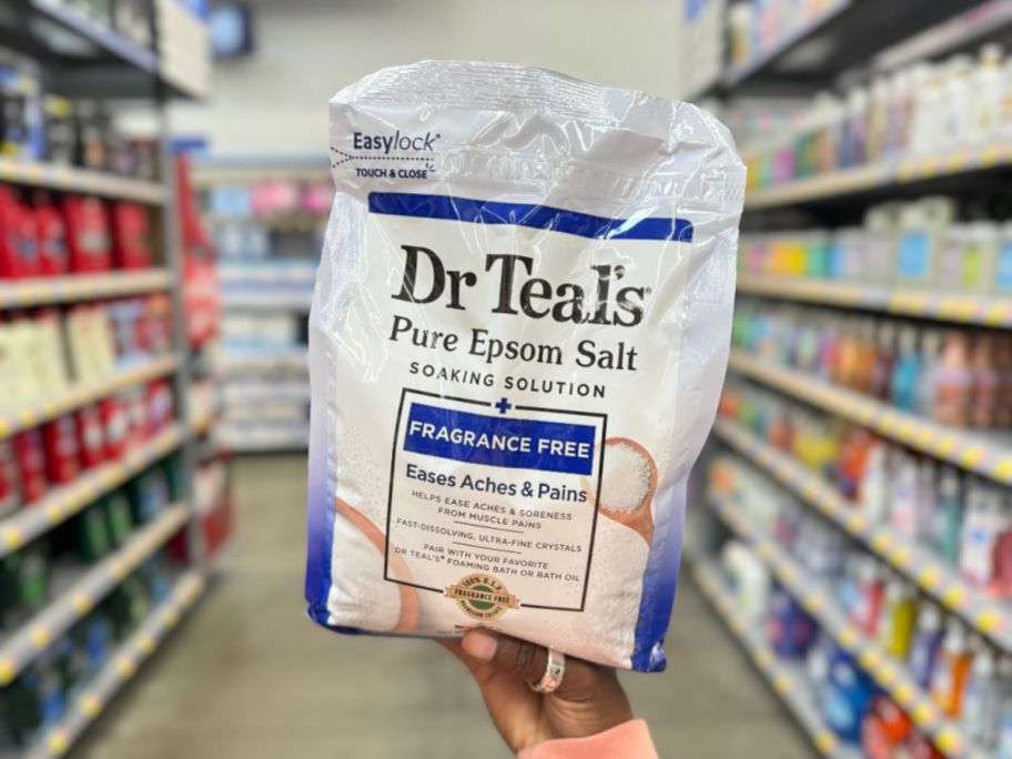 hand holding a large bag of Dr. Teal's Epsom Salt