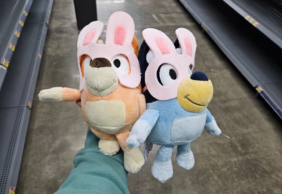 person's hand holding Bingo and Bluey Easter Plushes at Walmart