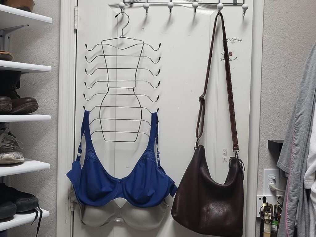 a Clodspac 8 tier closet organizer with bras on it hanging on a rack on the back of a closet door