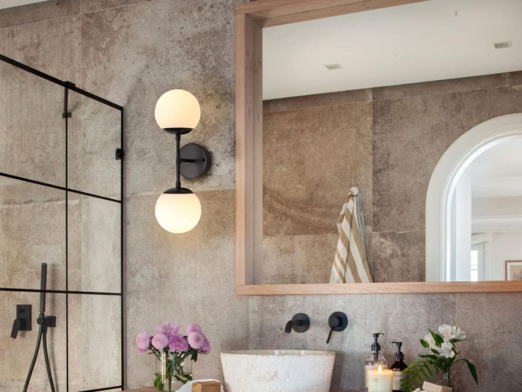 A bathroom with a glass sconce light on the wall