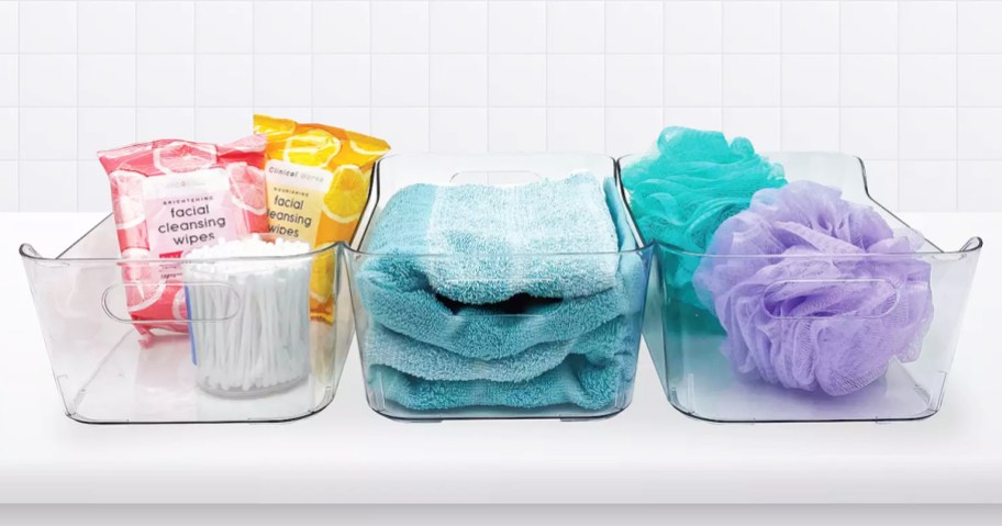 three clear plastic bins with bath products inside