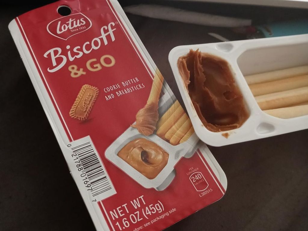 An unopened and opened pack of Biscoff & Go cookie butter and breadsticks snacks