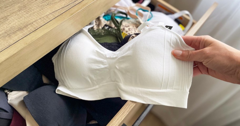 hand pulling a white bralette out of dresser drawer