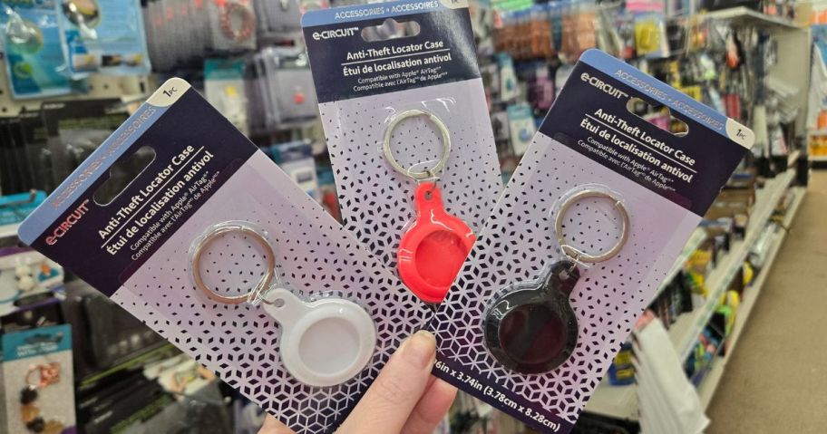 Hand holding three e-Circuit Airtag holders from Dollar Tree