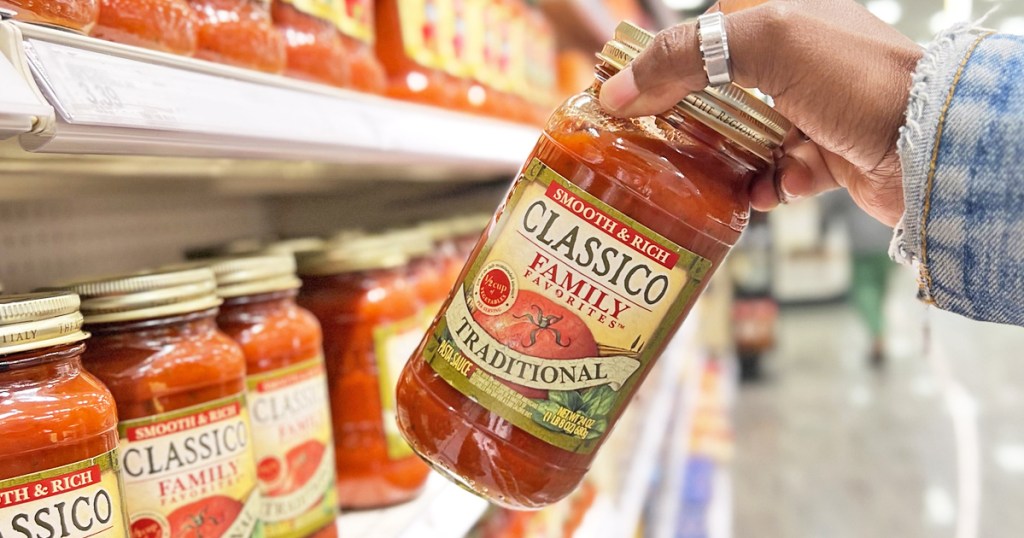 hand grabbing a jar of Classico Family Favorites Traditional Pasta Sauce from store shelf