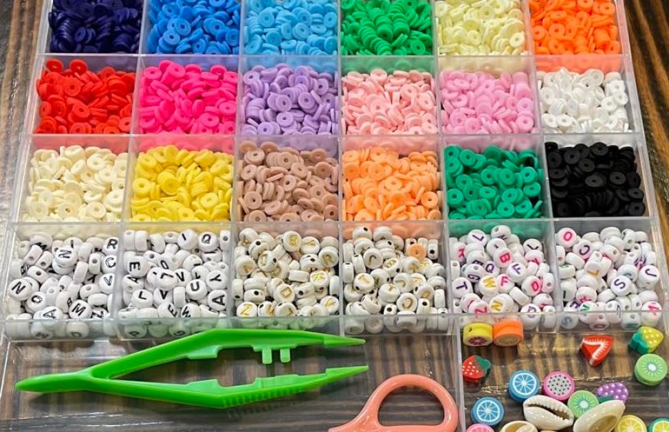 clear sorting box with colorful clay beads organized in them and tweezers
