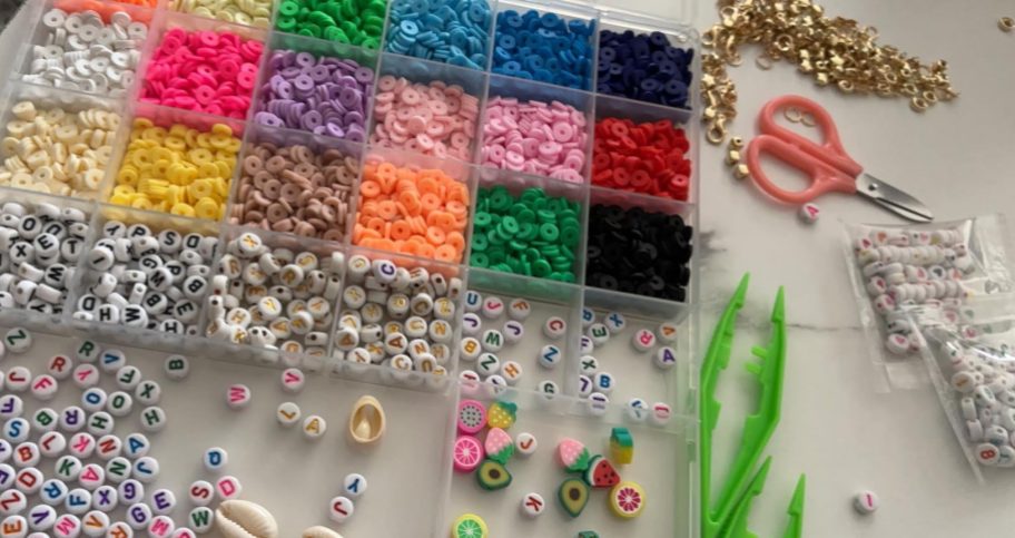 clear sorting box with colorful clay beads organized in them and tweezers