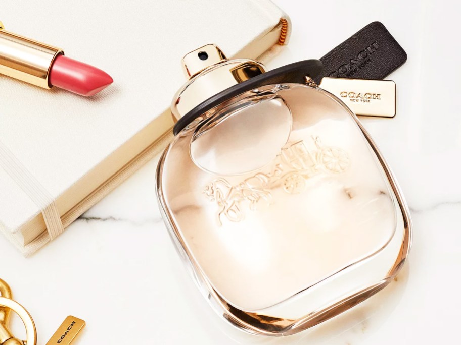 bottle of coach perfume on its side on a vanity