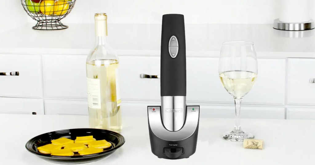 black and silver cordless wine bottle opener on kitchen counter near bottle of wine and wine glass