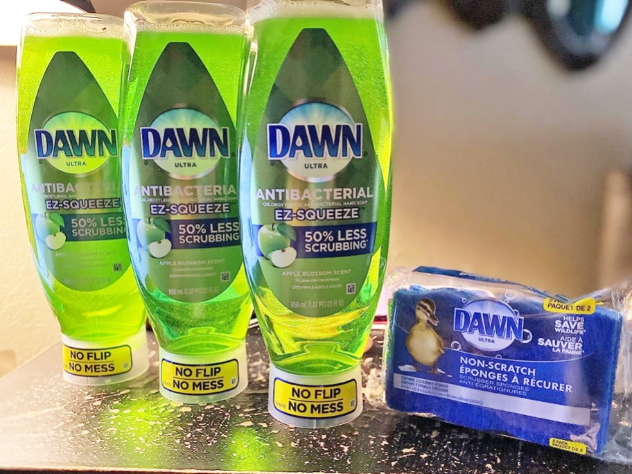 three green bottles of Dawn Antibacterial EZ-Squeeze Dish Soap with set of blue sponges