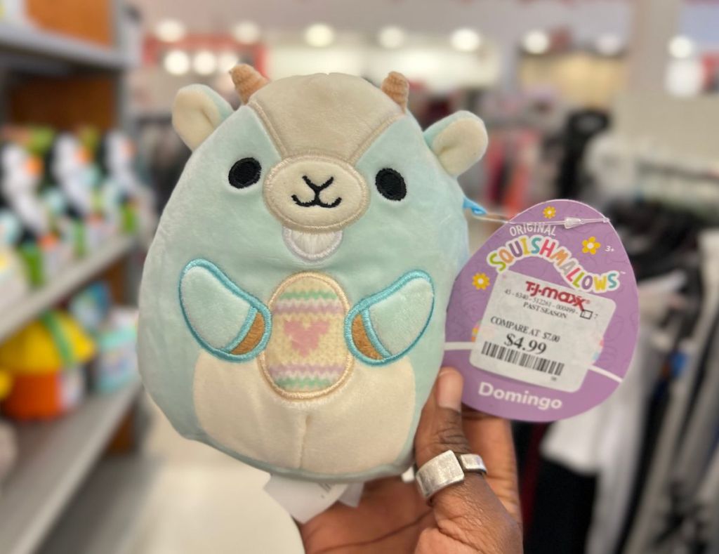 a womans hand holding a Domingo easter squishmallow