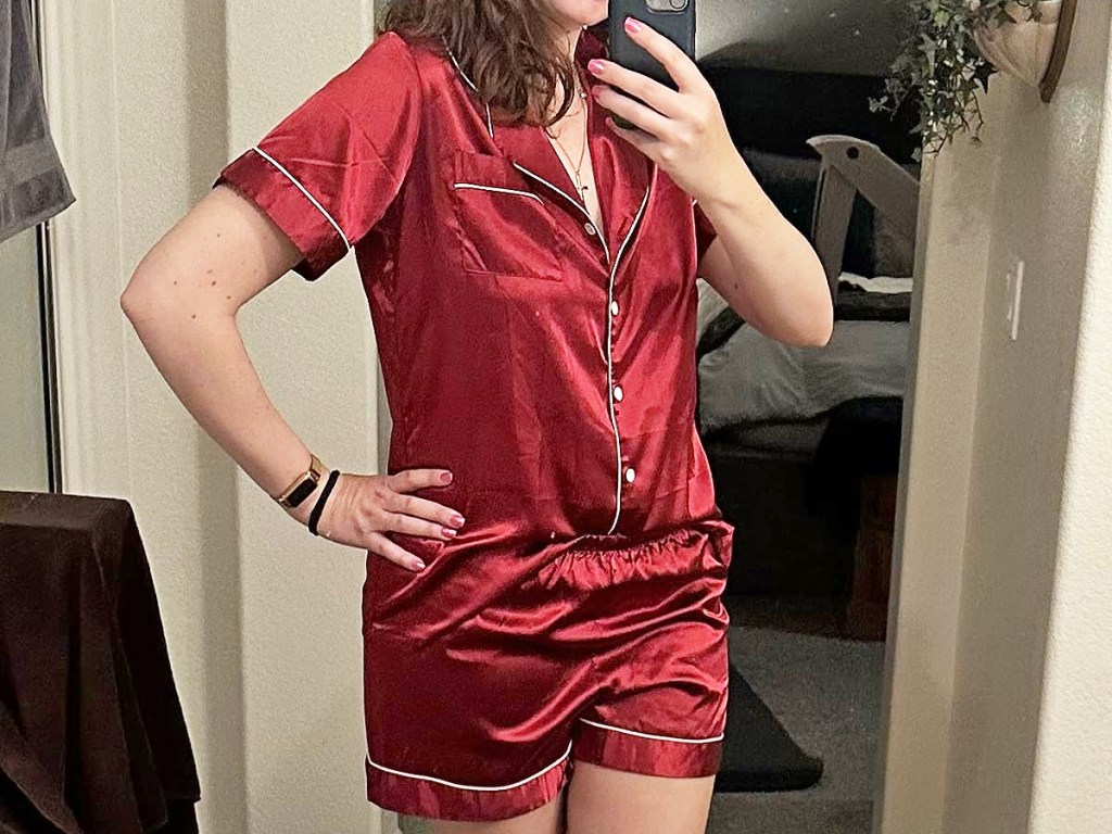 woman taking photo in mirror wearing red satin pajama set