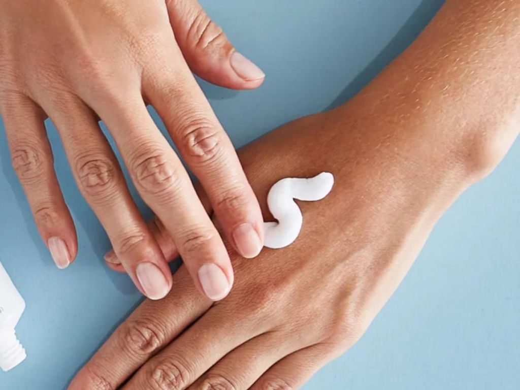 person rubbing Exederm Flare Control Cream on their hands