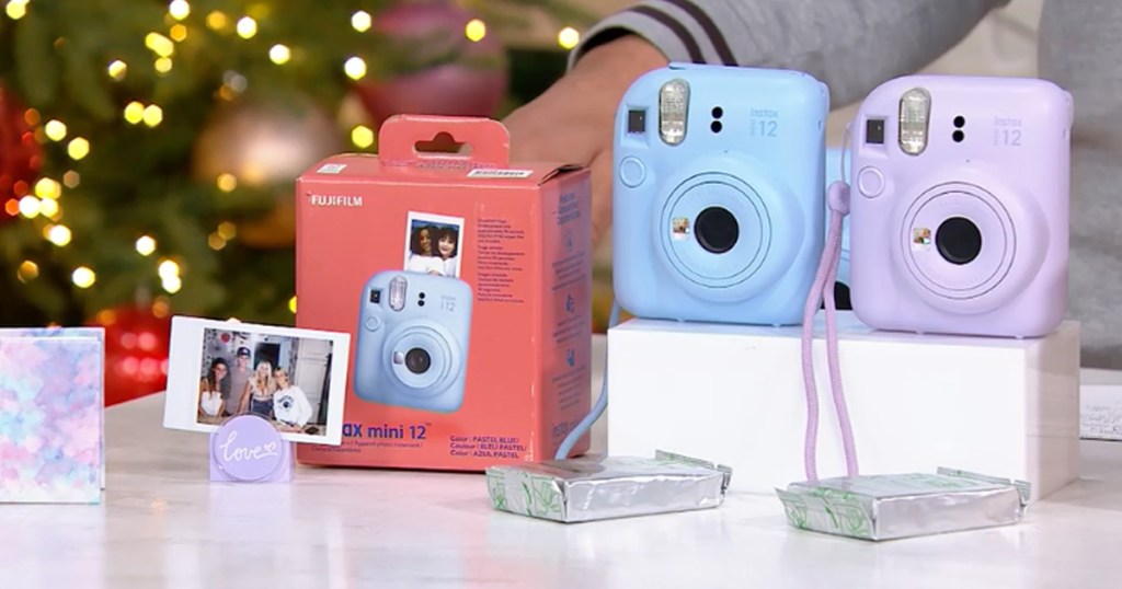 blue and purple Fujifilm Instax cameras on display table