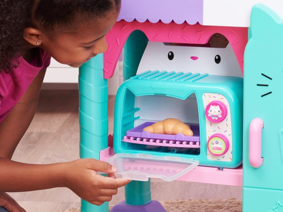 girl opening door to gabby's dollhouse oven toy