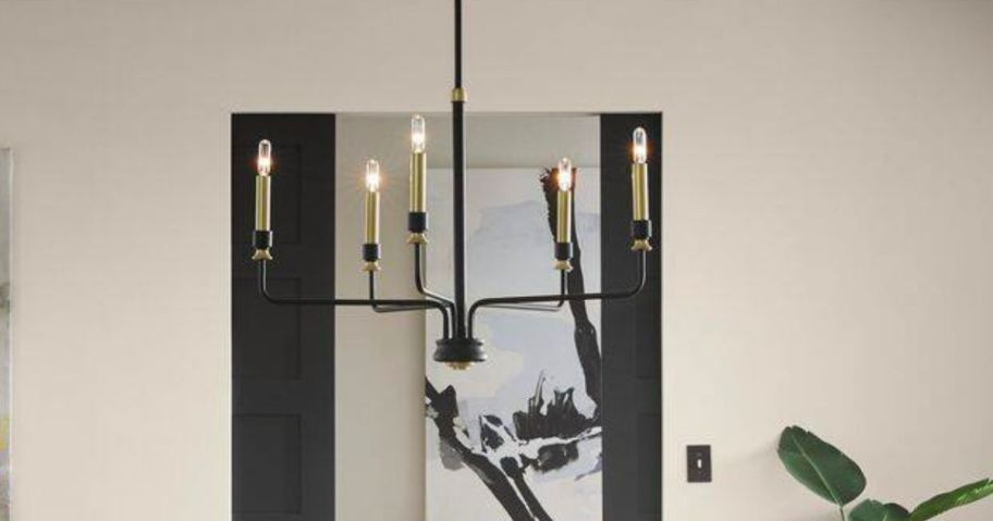 a black metal 5-light chandelier hanging from the ceiling