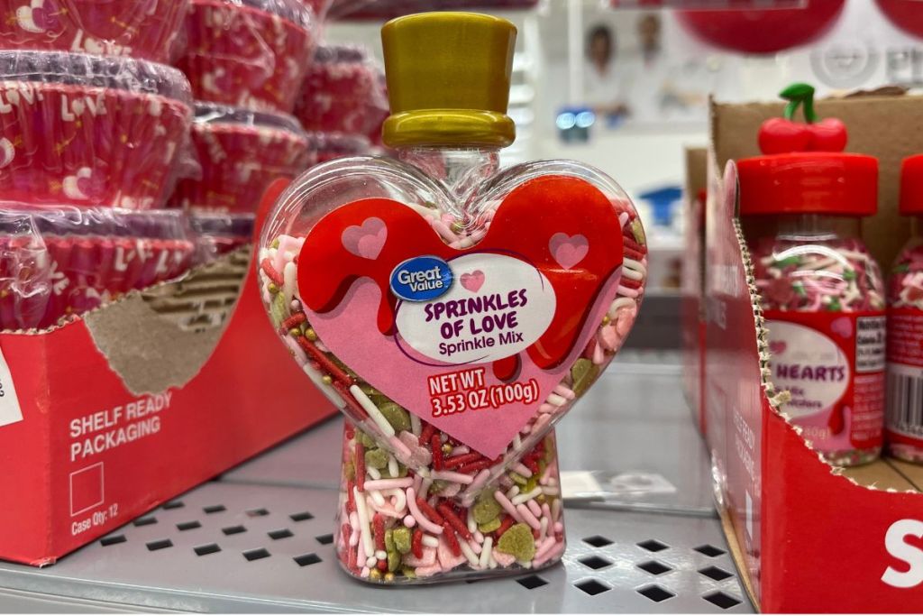 Great value sprinkles of love in aheart shaped bottle on a shelf in a walmart store