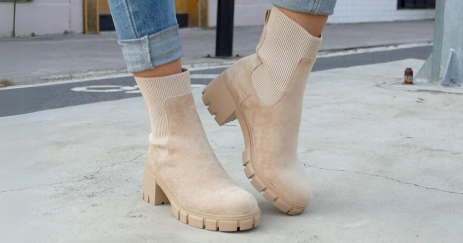 woman's feet wearing light tan suede Chelsea Ankle Boots