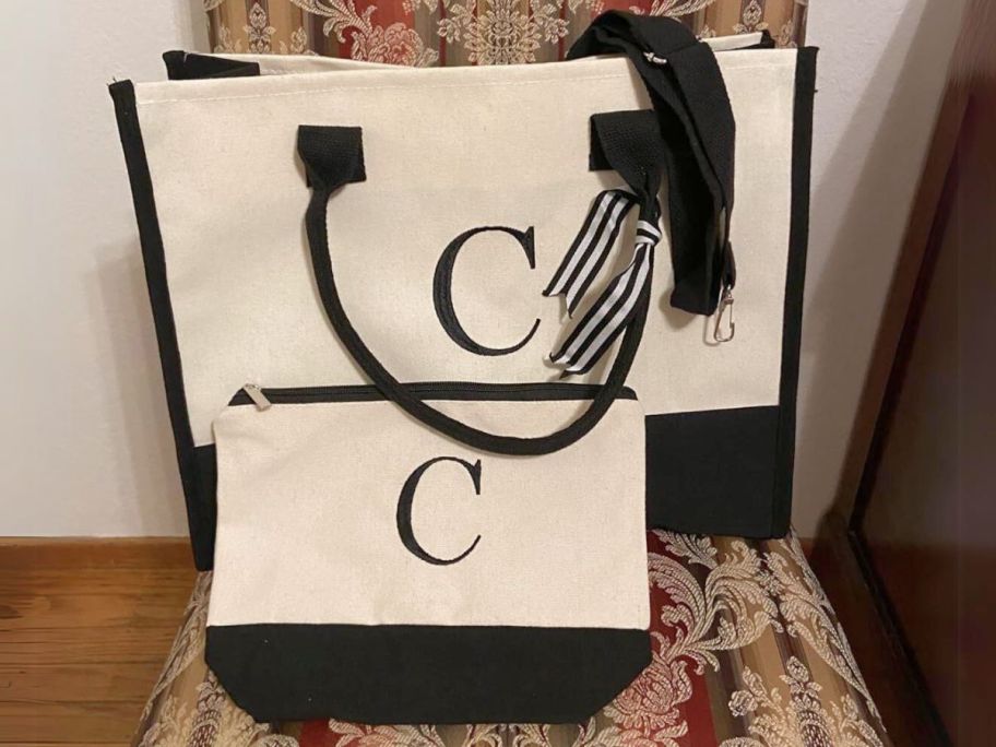 off white canvas bag and makeup bag with black accents and black initial "C"