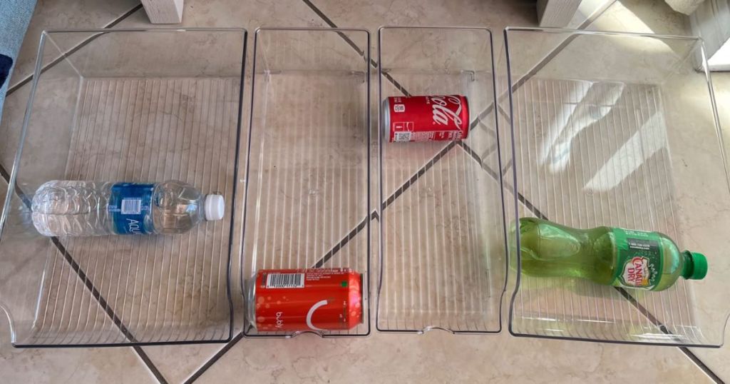 4 clear fridge or pantry organizer bins with soda cans and drink bottles in them