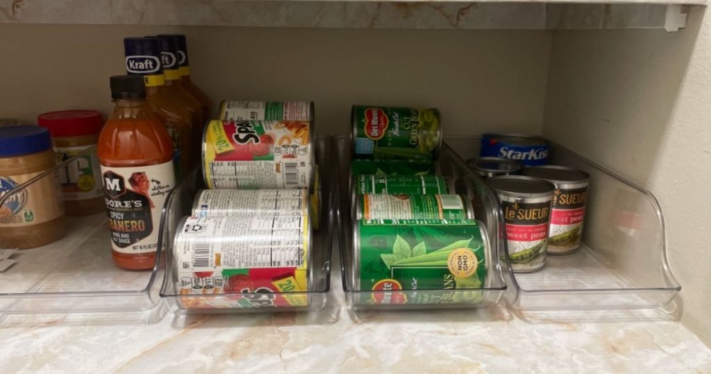 soda can organizer bins on pantry shelf holding canned food