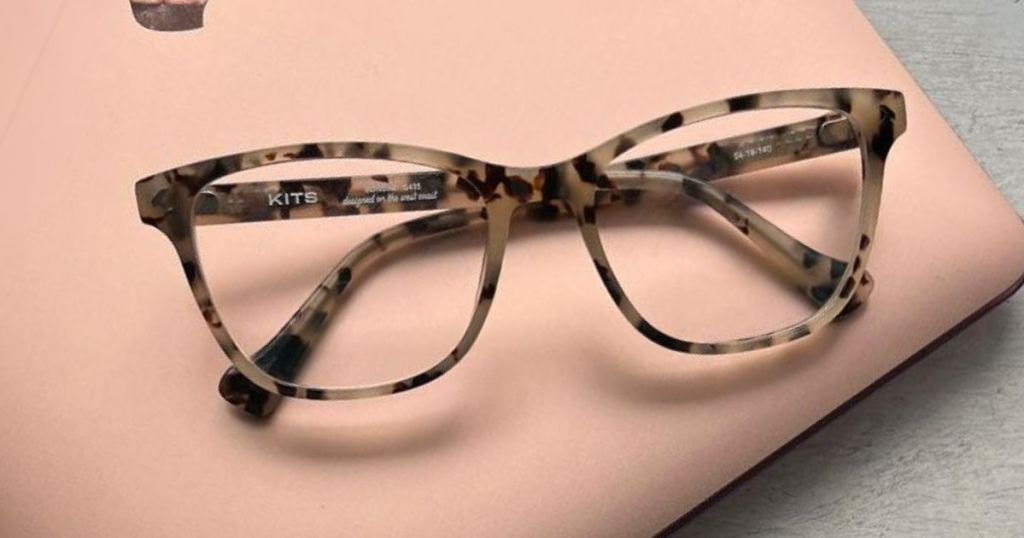 pair of brown tortoise shell eyeglasses laying on a peach laptop