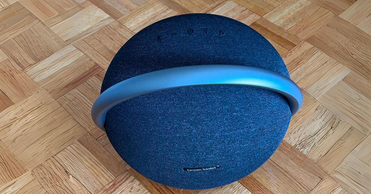 Harman Kardon Onyx Studio 7 Portable Bluetooth Speaker in blue sitting on a parquet wood floor