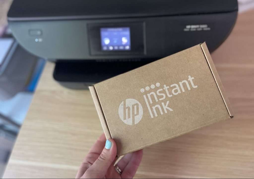 An HP Instant Ink Box next to a home printer