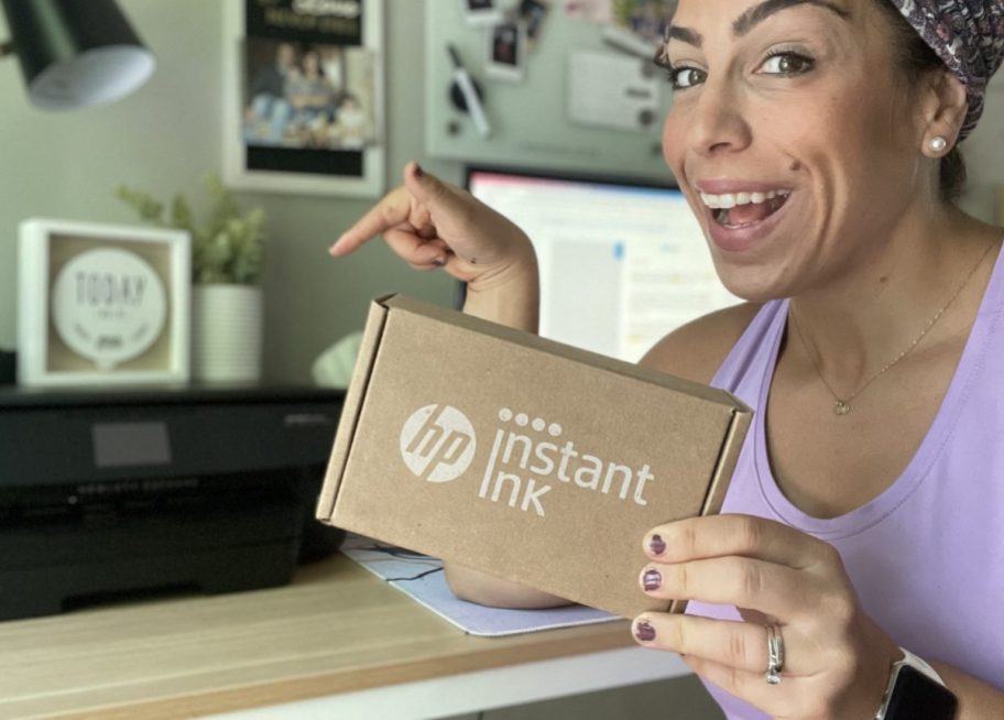 Woman holding an HP Instant Ink subscription