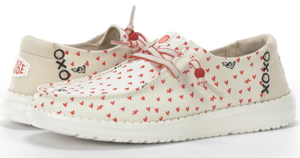 pair of Hey Dude shoes with white background and red hearts 