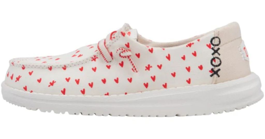 white Hey Dude kid's shoes with red hearts and XOXO on the side