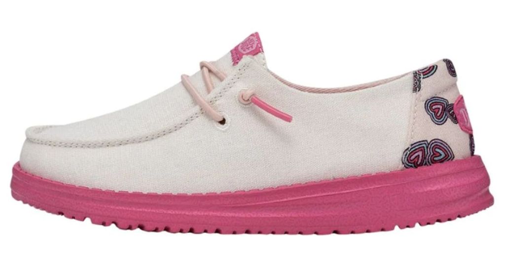 kid's Hey Dude shoe with pink sole, white upper and pink/black hearts on the heel