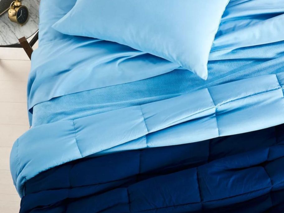 light blue and dark blue reversible comforter on bed