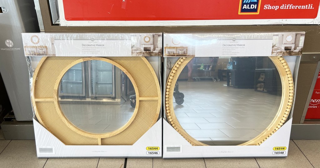 two round wall mirrors leaning against wall in store