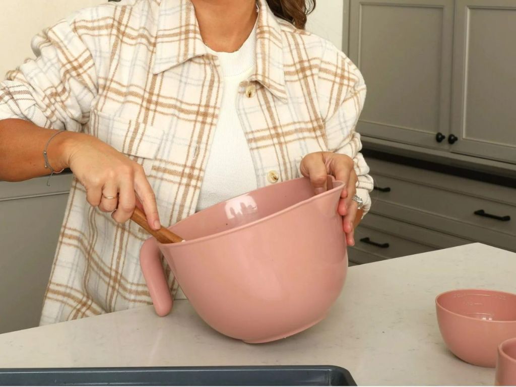 A woman in a kitchen stirring a Just Feed Me Bowl