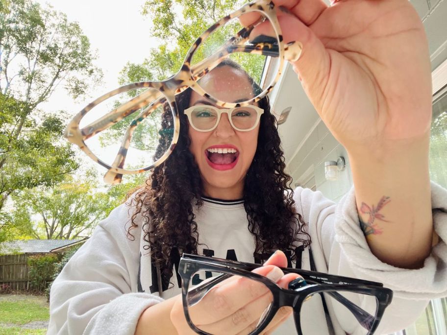 Woman holding up several pairs of Kits Glasses