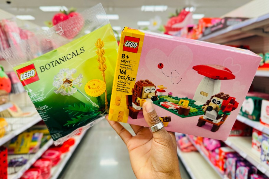 hand holding two LEGO sets in aisle