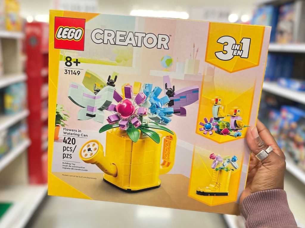 Hand holding up a box of the LEGO creator 3-in-1 watering can building set