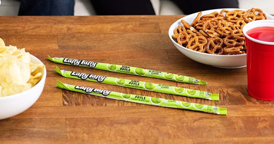 green laffy taffy ropes on wood table near other snacks